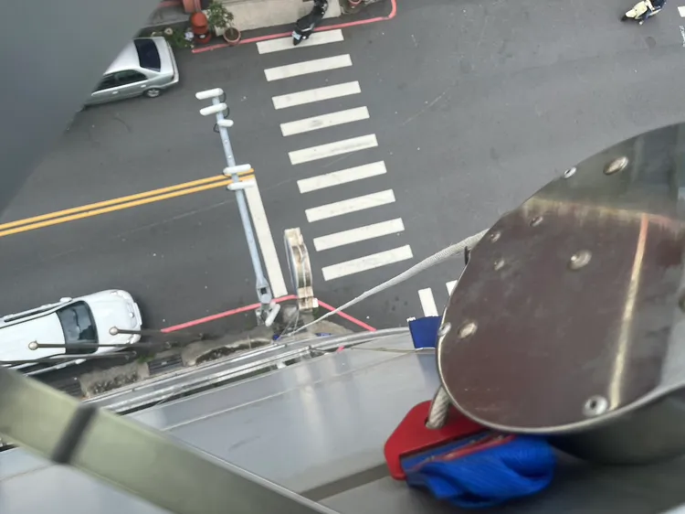 員警從七樓往下望，發現逃生緩降設備掉落路面。讀者提供