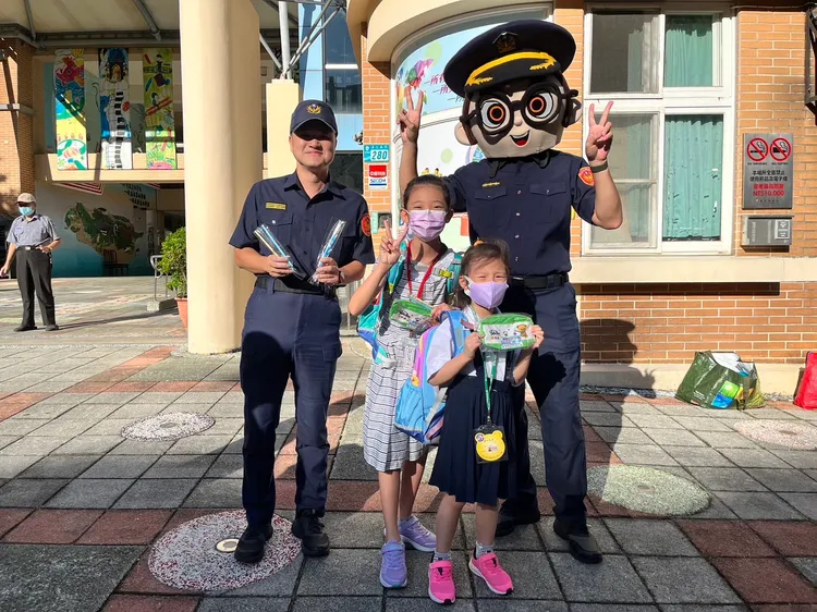 海山警分局警員與警察大頭娃娃一起站路口，守護用路行人安全。警方提供