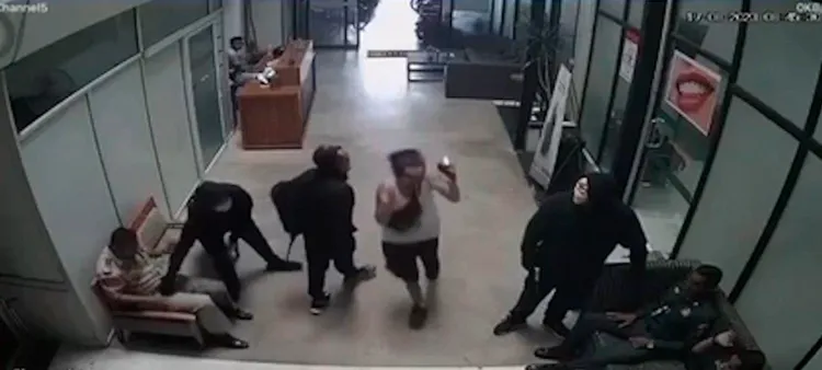 劫匪限制獄警行動時，一名白衣婦人快步逃離現場。翻攝《高棉時報》