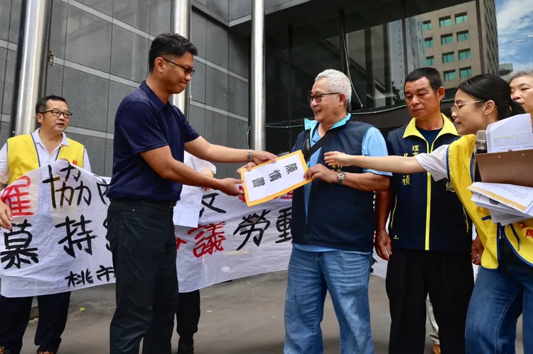 台灣科慕企業工會理事長洪天寶，遞交陳情書給勞動部勞動關係司科長金士平。林林攝