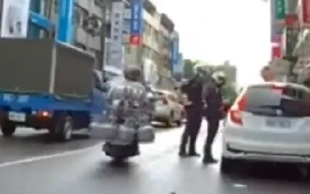 騎士載7桶瓦斯穿梭街道，還大方從警員身邊駛過。取自社會事新聞影音群組