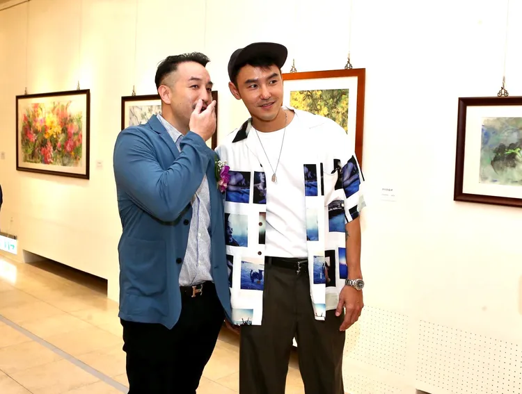 唐志中（左）和阮經天講悄悄話。彭欣偉攝