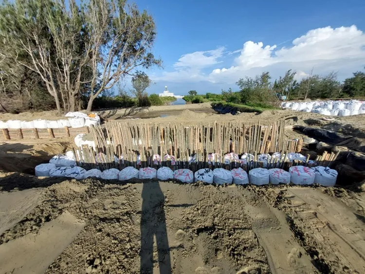 林業署打樁編柵及太空包覆土圍堤完成雙春海堤破口封堵。水利局提供