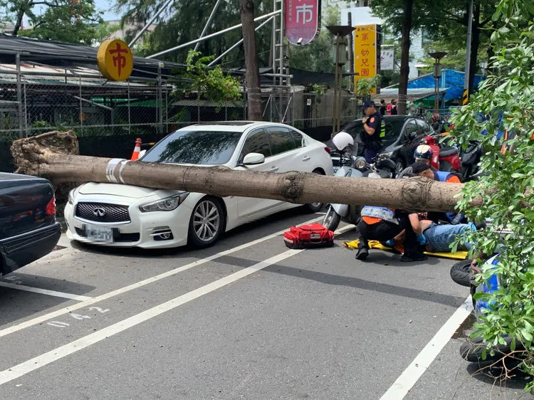 騎士受傷倒地，警消派員救護送往新樓醫院。讀者提供