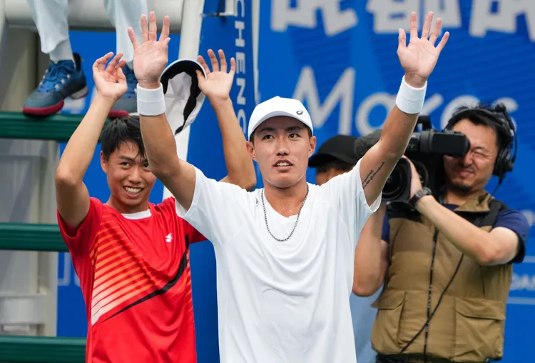 許育修（白色球衣）、黃琮豪向觀眾致意。新華社