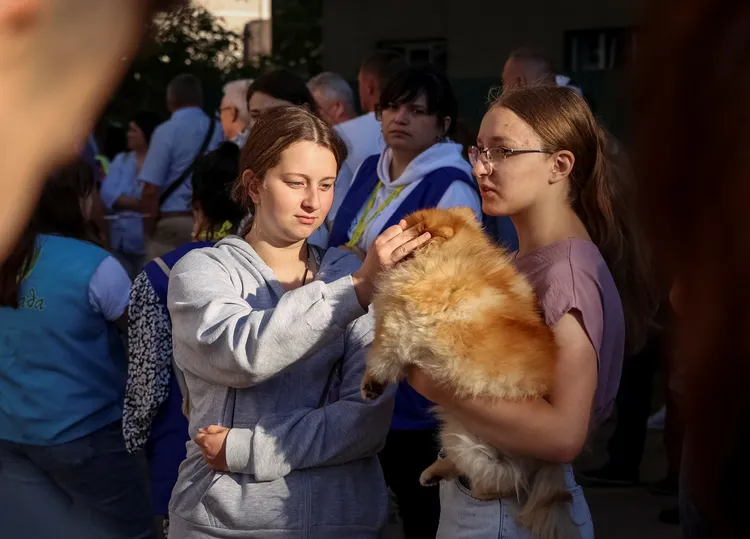 民眾抱著狗狗躲空襲。路透社
