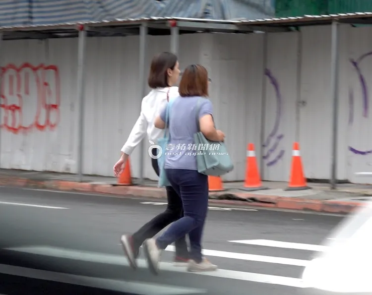 2人勾著手一起過馬路，感情看似不錯。特勤中心攝