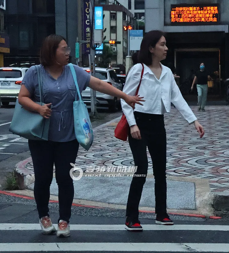 蔡依珊（右）準備過馬路，女友人發現來車趕緊攔住。特勤中心攝