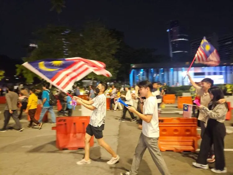 馬來西亞8月31日舉行獨立66週年國慶日慶祝活動，圖為吉隆坡市政局30日晚間安排各民族舞蹈表演，民眾揮舞國旗。中央社