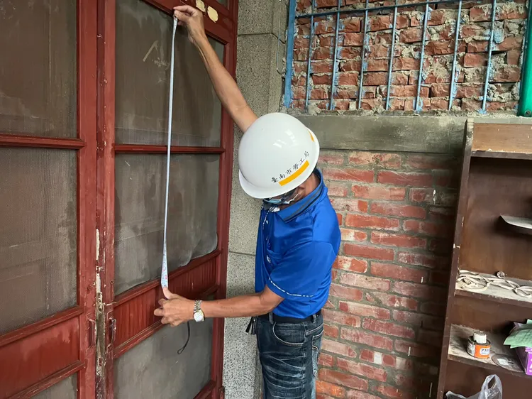 志工丈量尺寸。勞工局提供