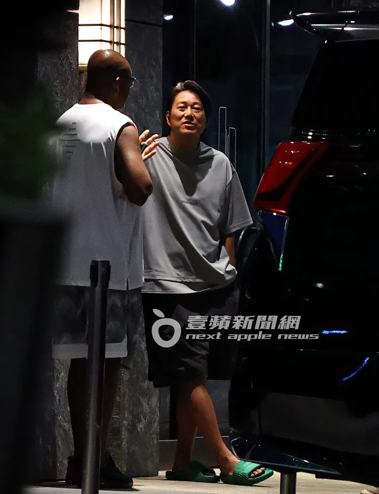 韓哥（右）走回酒店，在門口與身材魁梧，貌似《玩命關頭》唐老大的光頭老外暢聊。特勤中心攝