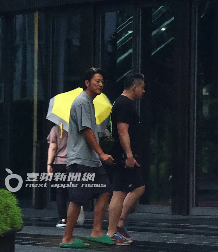 雨勢稍緩，韓哥（左）穿著休閒裝扮，與友人步出酒店透透氣。特勤中心攝