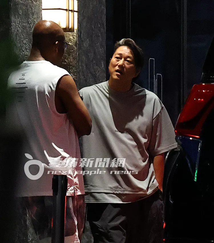 韓哥（右）在酒店門口，與酷似「唐老大」的光頭老外再續前緣交談。特勤中心攝