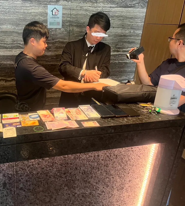 男保全落網後雙手被銬，警方當面清點贓款。翻攝畫面