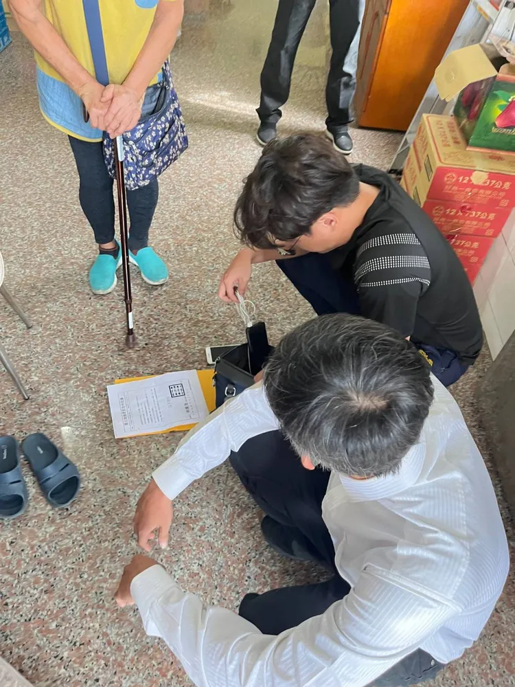 車手(白衣)現身即遭警方控制逮捕。讀者提供