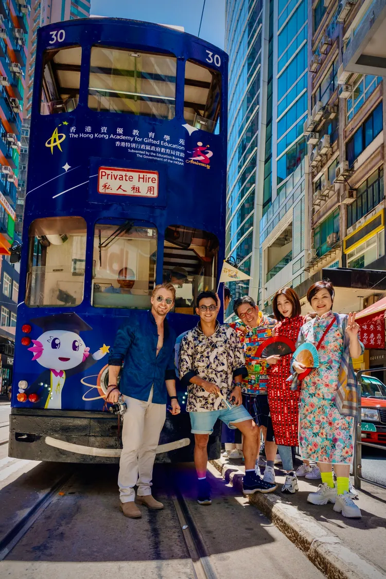 法比歐（左起）、威廉、洪都拉斯和穿旗袍的曾莞婷、楊貴媚等，在香港與復古叮叮車合影留念。東森綜合提供