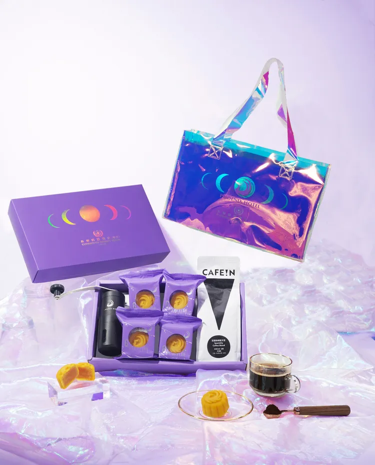 《鳳凰迎月-醇萃版》中秋月餅禮盒以幻彩宇宙手提袋盛裝鳳凰奶凰月餅4入、CAFE!N冠軍單品咖啡豆、鳳凰手搖磨豆機，香醇咖啡佐奶凰月餅。業者提供
