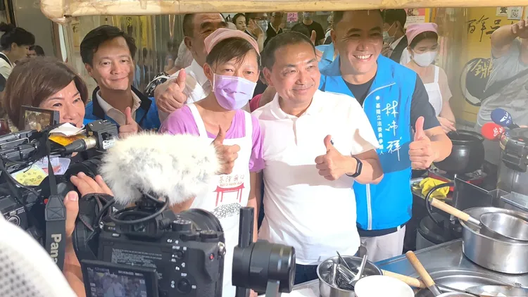 侯友宜在多位市議員陪同下，品嘗廟口美食吳家鼎邊趖。葉先鵬攝