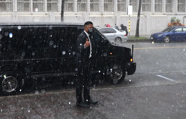 陳建州在暴雨中比讚。資料照片。彭欣偉攝