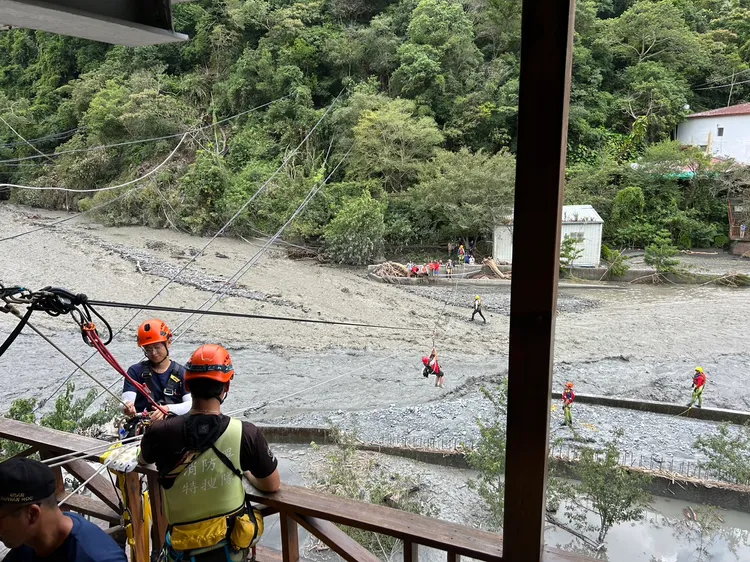 消防人員以架設繩索拖拉系統的方式，協助廬山溫泉區21名遊客、居民脫困。南投縣消防局提供