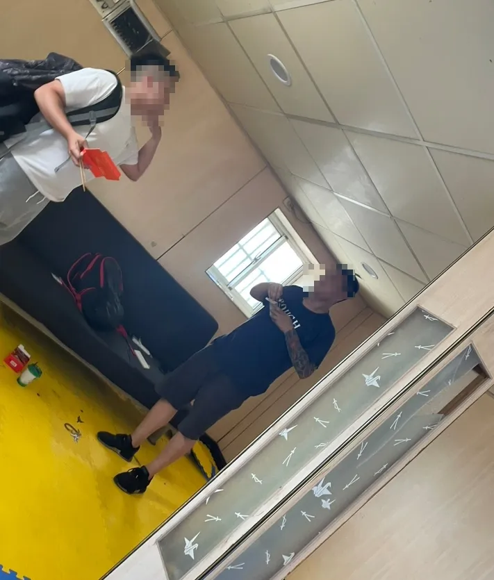 A男趁隙偷拍控制他行動的刺青男。民眾提供