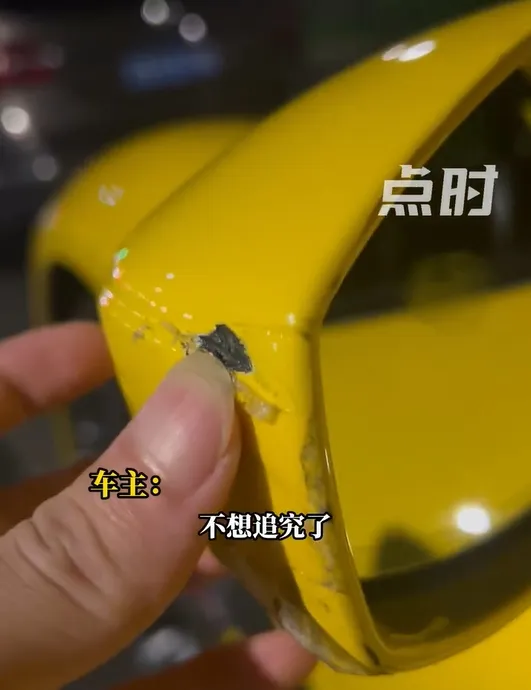 法拉利車主心疼的看著被刮花的後照鏡。取自微博