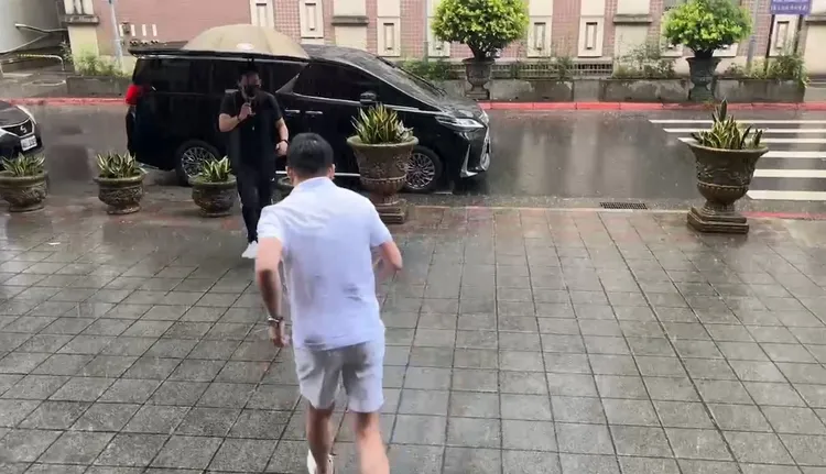 汪小菲原本沒撐傘跑向座車，但助理隨即拿傘走上前。陳彩玲攝