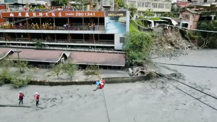 對岸十多名警消人力拖拉，協助民眾半空橫渡脫困。台中消防局提供