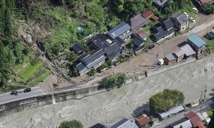 鳥取市一處道路16日受到暴雨引發的洪水阻斷通行。美聯社