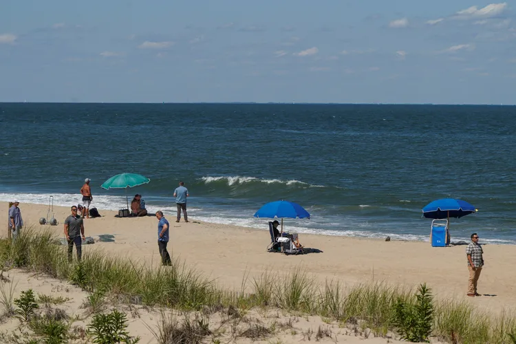 拜登夫妻（中）在密勤人員環伺下享受海灘日光浴。美聯社
