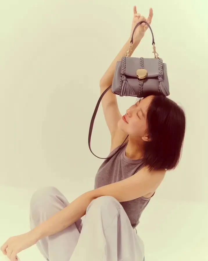 項婕如手拿風暴藍迷你肩背手提包，展現俏皮樣貌。品牌提供