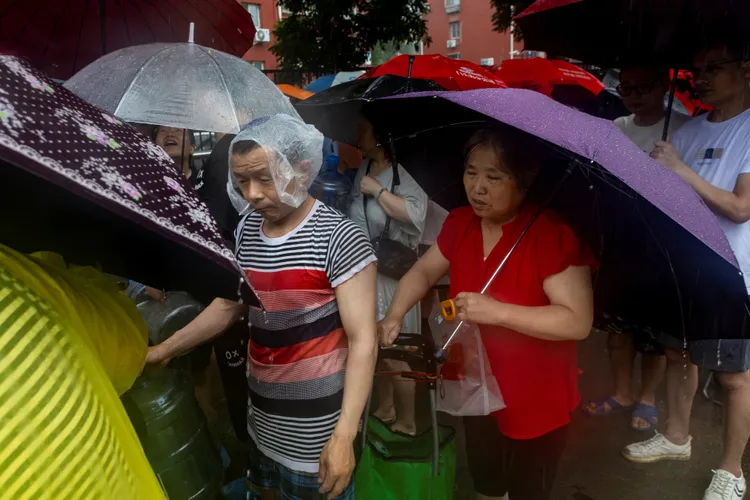 北京民眾冒雨排隊領取飲用水。路透社