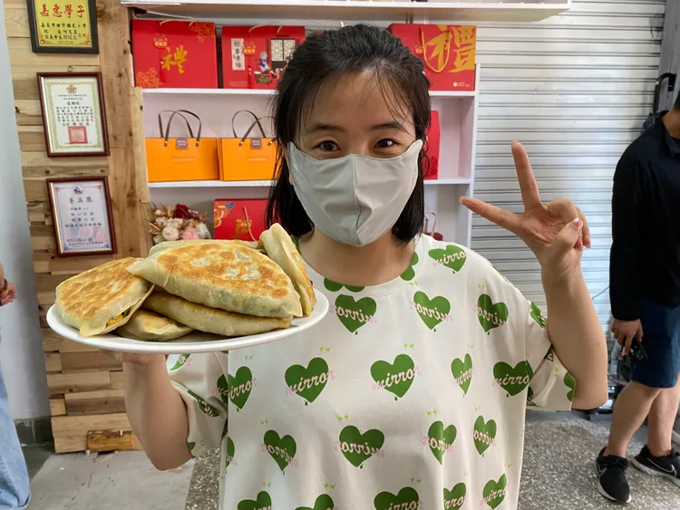 新住民君慈展示韭菜盒子成品。移民署提供