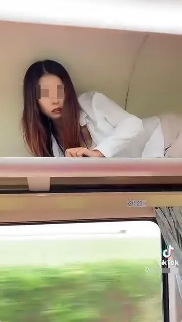 女子傻眼趴臥在火車行李架上，台鐵局認為可開罰。取自「台灣便當管理局-附屬鐵路部」