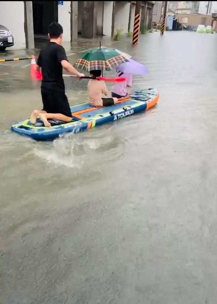 孩子撐傘、大人划槳，畫面愜意。讀者提供