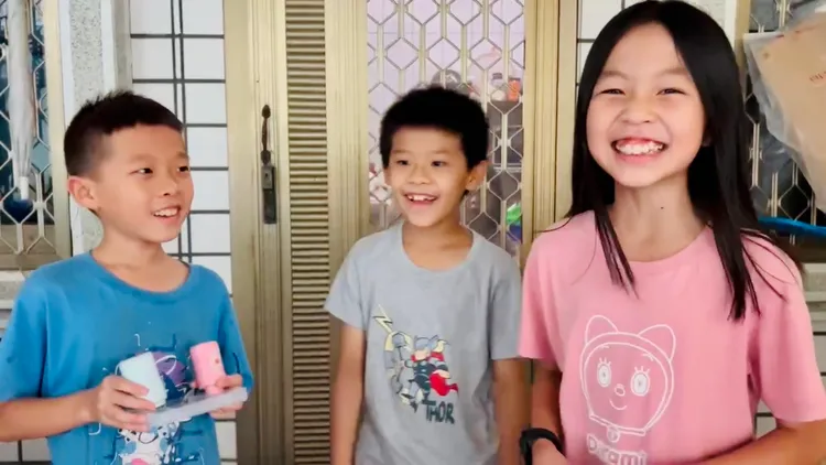 3名孩童開心分享淹水搭船樂。讀者提供