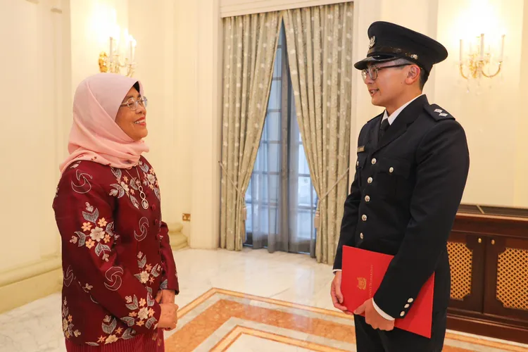 哈莉瑪（左）頒發獎學金給蔡家智，他將赴美求學，之後加入新加坡警隊。翻攝哈莉瑪臉書@Halimah Yacob 