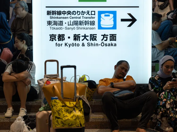 滯留東京站的旅客等到閉目小憩。新華社