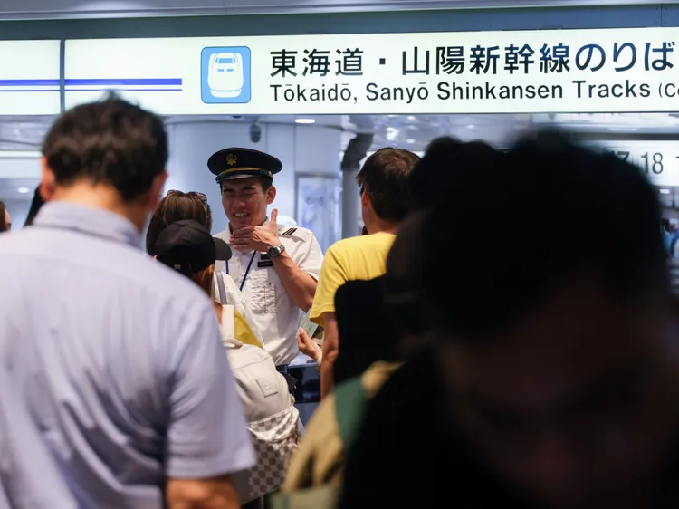 新幹線工作人員在東京站接受旅客詢問。新華社