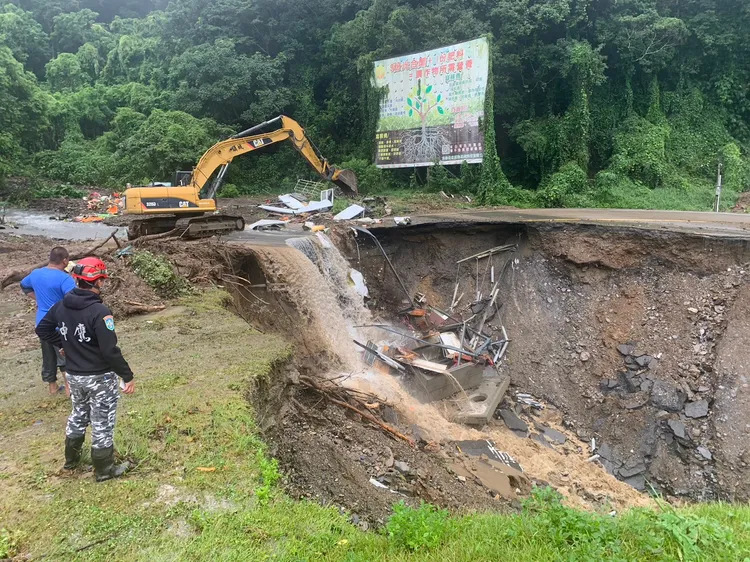 大型重機具開挖搶通部分道路，搜救人員步行至對面，再由對面開接駁車載救災人員前往災區。台中市消防局提供
