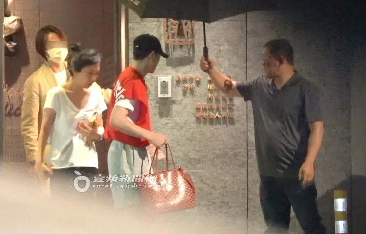 蕭敬騰（中）提著Goyard寵物袋回頭，怕未婚妻淋到雨，Summer拿著水和錢包緊跟在後。特勤中心攝