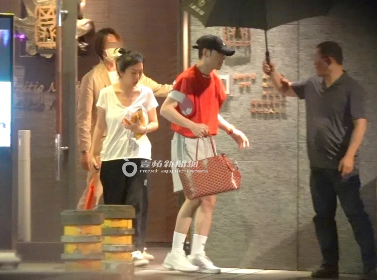 蕭敬騰（中）提約5萬2千元的Goyard寵物袋，跟拿藥袋及水壺的未婚妻Summer，離開中醫診所。特勤中心攝