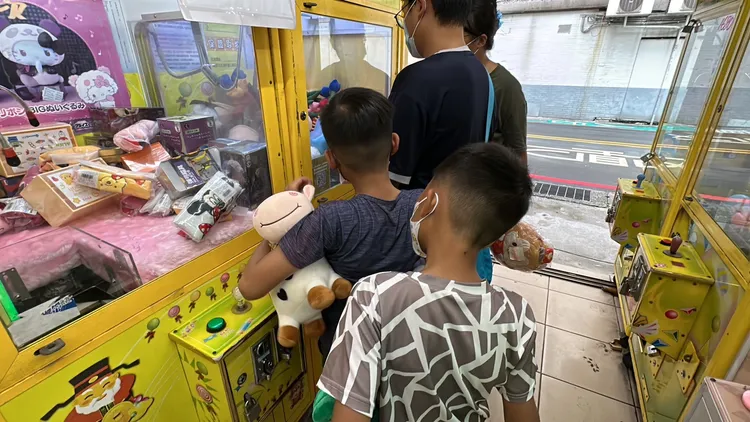 有家長帶著小朋友來玩夾娃娃機，對於新條例限制上路，覺得沒有多大差別。曾佳俊攝
