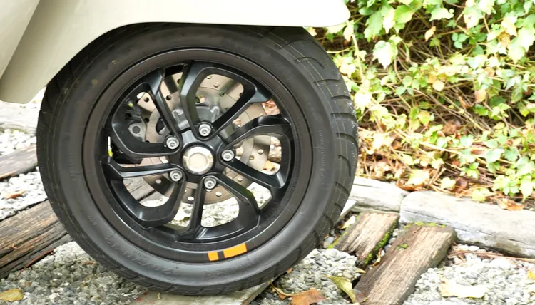 雙肋五輻式的12吋鋁圈，也有橘色車貼點綴。黃天佑攝