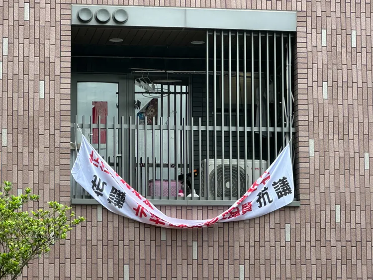 明倫社宅長者租客堆雜物飄異味，鄰居拉白布條抗議。陳怡君提供