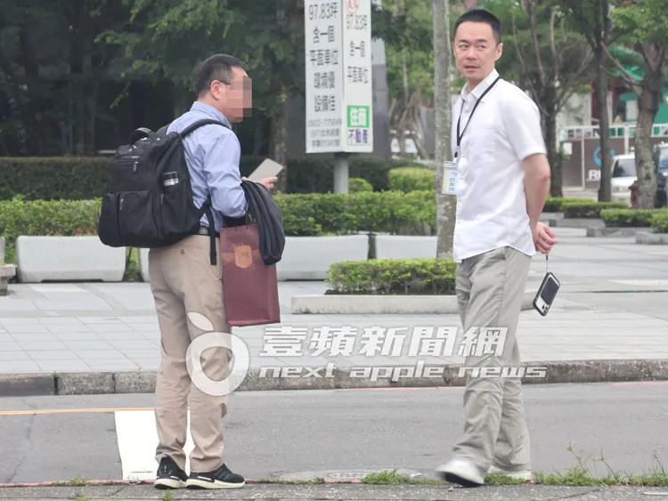 張承中（右）貼心陪友人等待計程車抵達。特勤中心攝