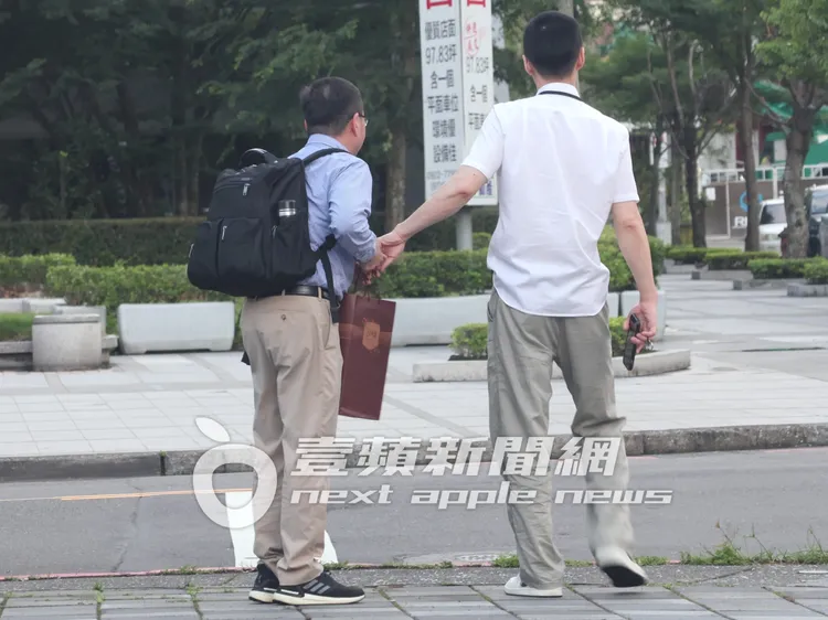 張承中（右）等計程車快到時，將伴手禮交還給友人。特勤中心攝