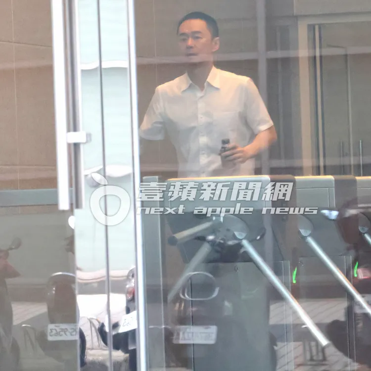 張承中手拿飲料走進商辦大樓。特勤中心攝