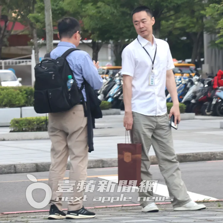 張承中（右）陪友人在路邊等車。特勤中心攝