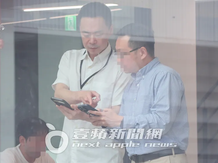 Selina前夫阿中（左）和友人共享手機畫面，認真討論。特勤中心攝